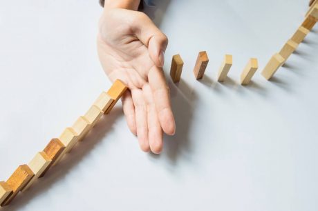 Una mano ferma il domino Immagine di una mano che ferma il domino
